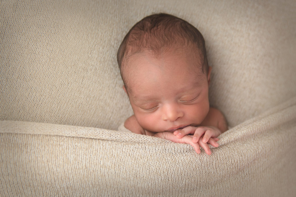 closeup of newborn sleeping under a blanket