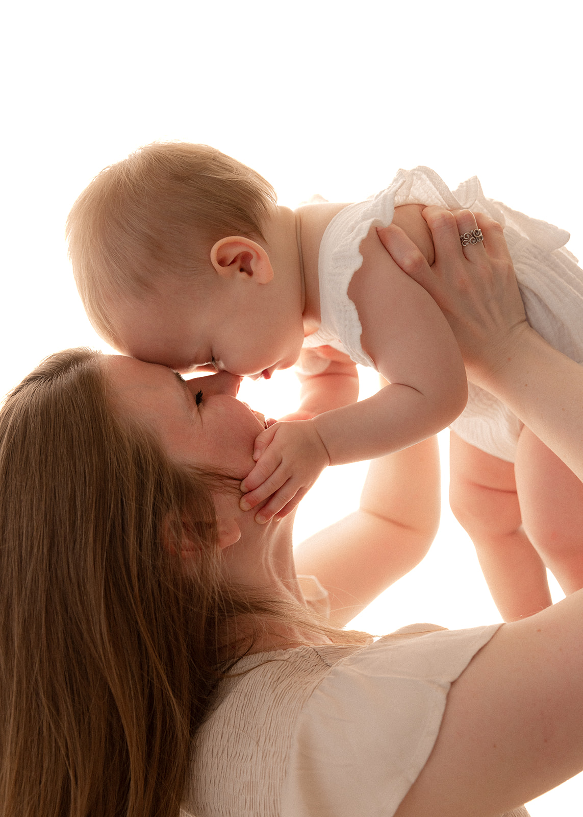 mom holding her toddler toddler up in the air