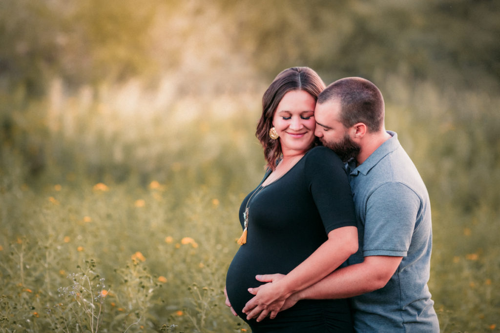 a husband hugging his pregnant wife