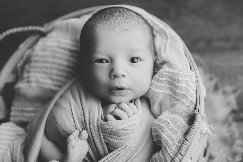 black and white photo of an awake newborn