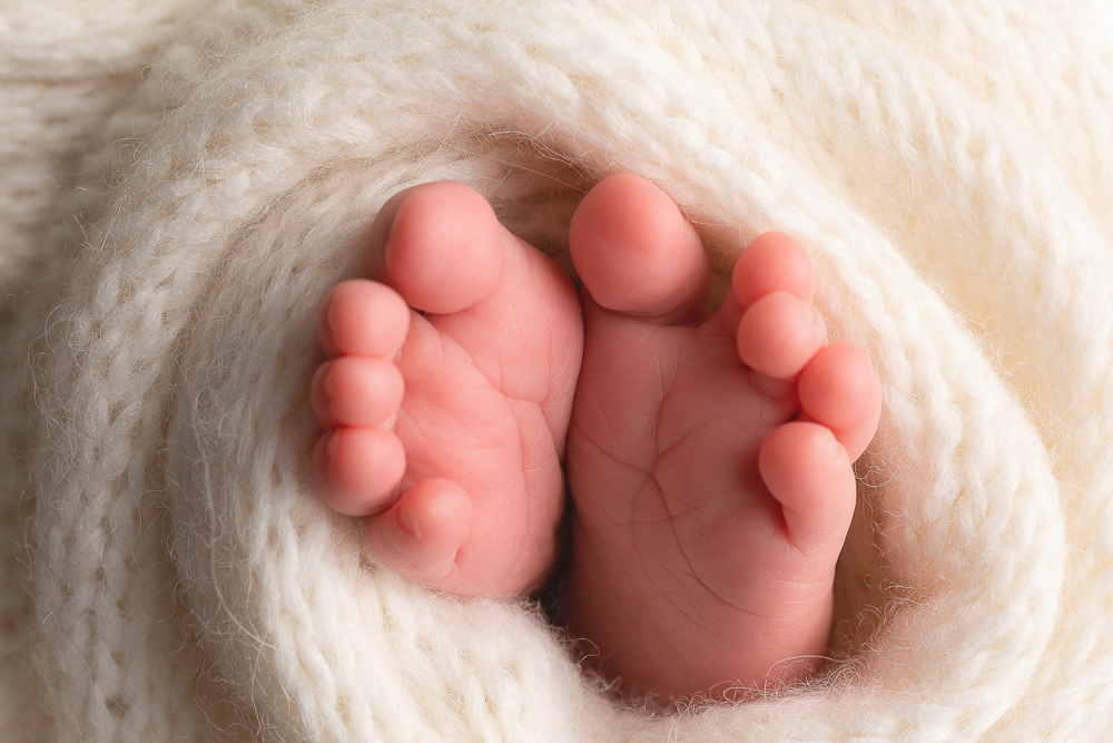newborn baby feet peeking out from a blanket